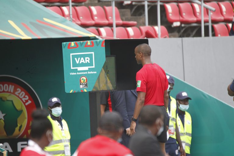 Arbitro consulta il monitor VAR durante una partita di calcio
