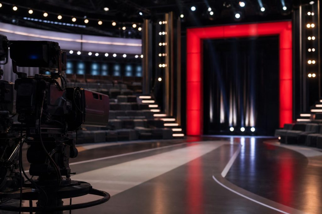 Studio televisivo reality con porta rossa e telecamere
